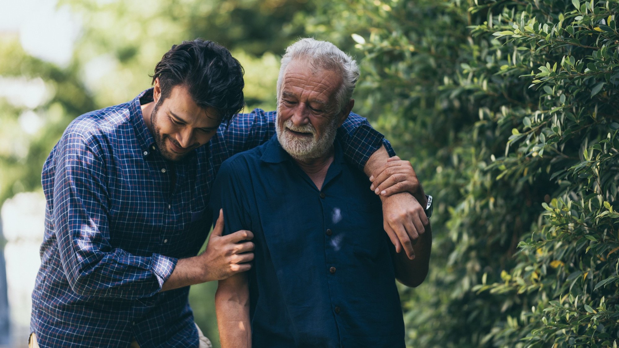 A supportive moment between an older and younger man, representing the continuity of family business through generations.